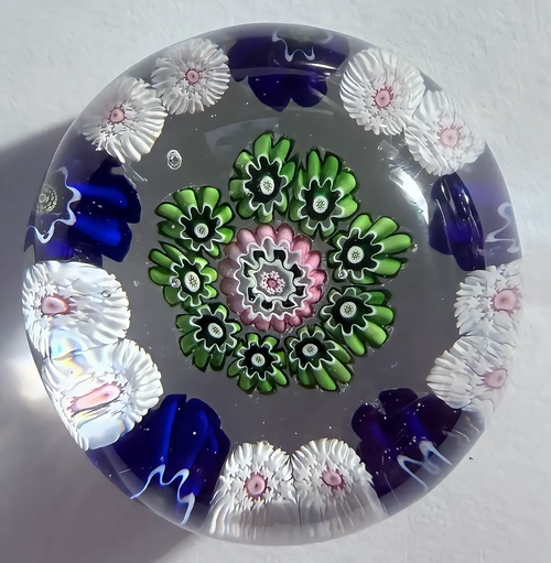 Antique Clichy with outer ring pattern of two white stardust canes with pink centers and one blue pastry mold complex canes with green centers,an inner ring of 9 green pastry molds surrounding a nice pink pastry mold center complex cane. Clear Ground. High flat dome. 1.62"