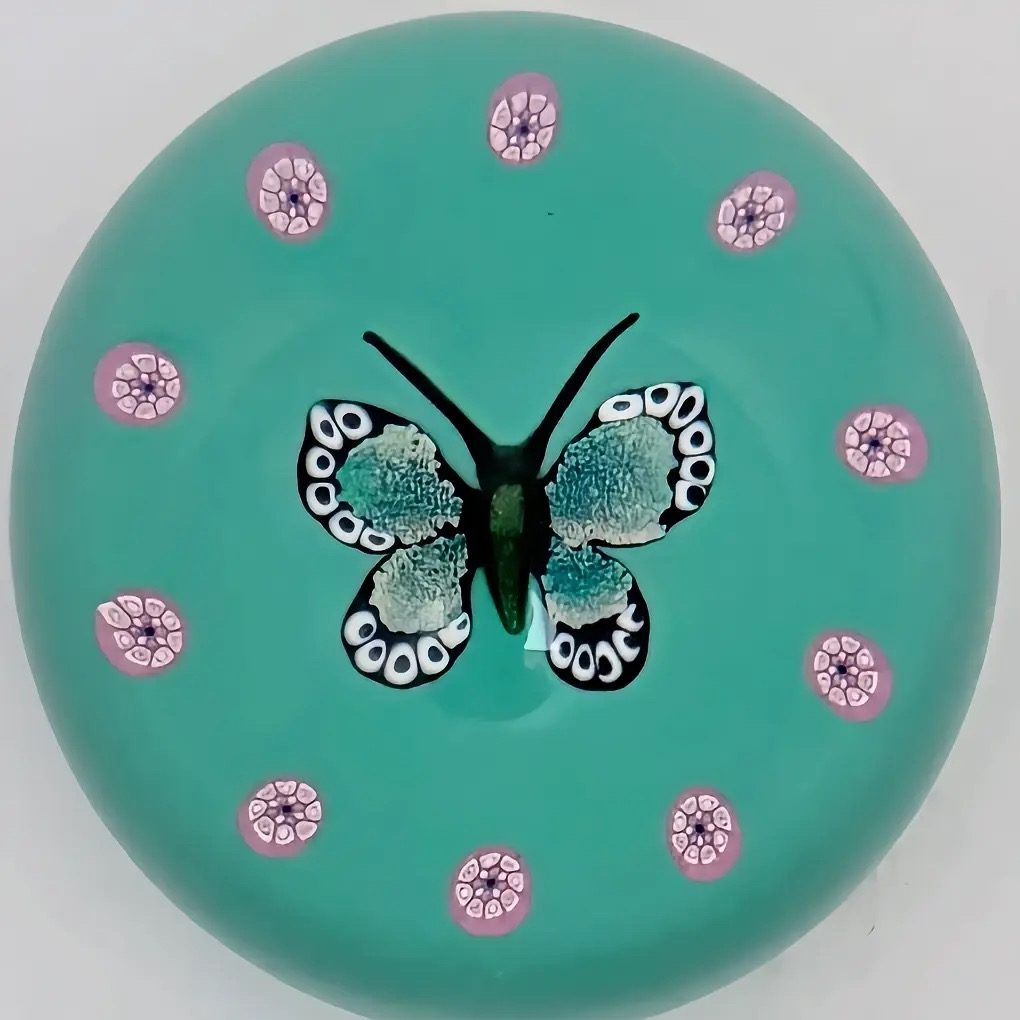 A 2002 William Manson Snr. 1/1 aventurine butterfly on a nice opaque teal ground surrounded by a cane garland. 2.7". Scratch signed on base.