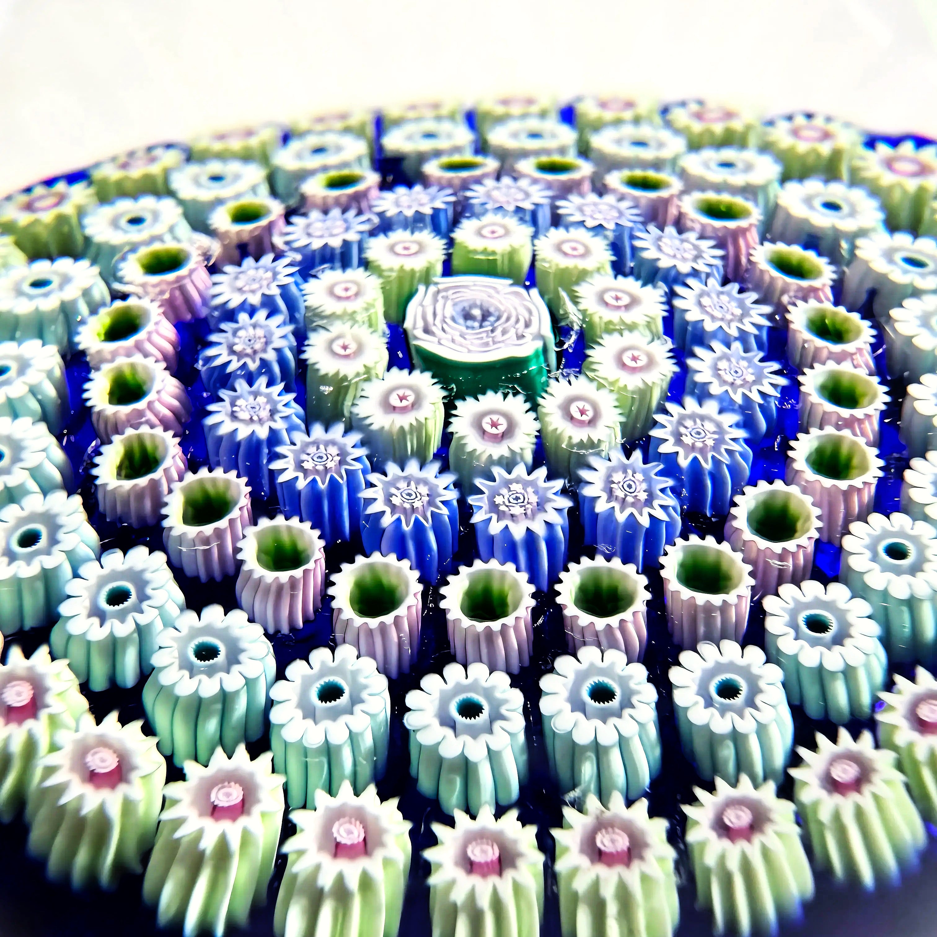 Deacons Glass 5 concentric rows of tight and crisp millefiori surrounding by a center Clichy style rose a top a translucent cobalt ground. Lovely weight. 2.80"